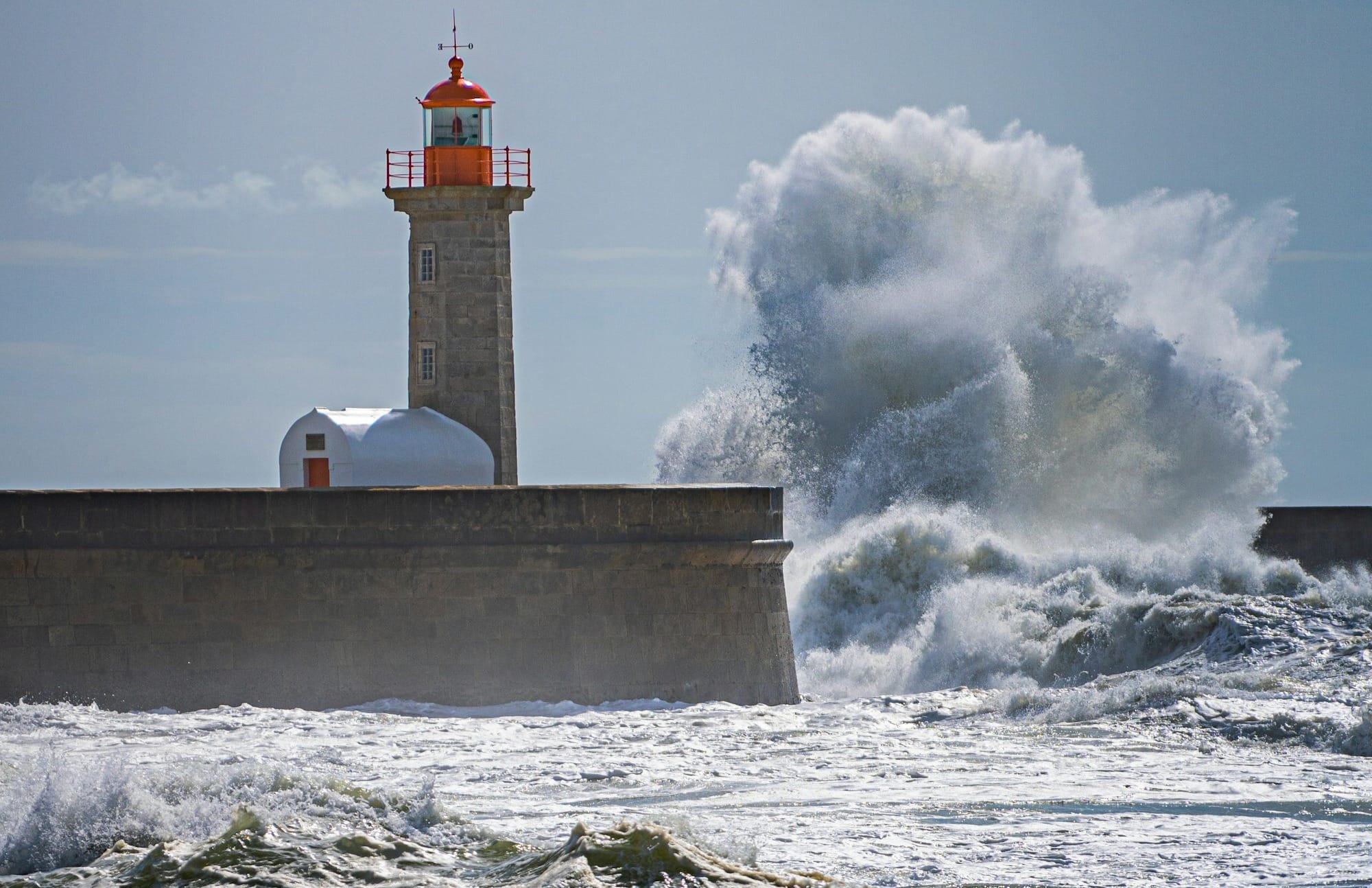 a lighthouse surrounded by waves in the ocean